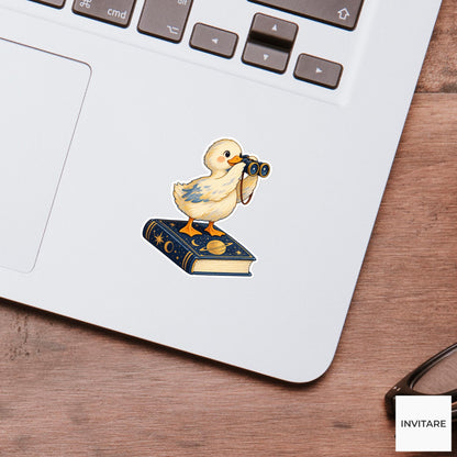 Duck looking through tiny binoculars while balancing on a closed astronomy book Vinyl Sticker
